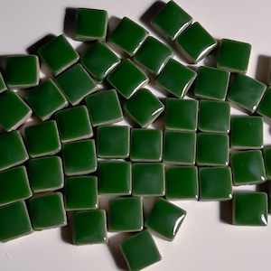 May include: A collection of small, square, green ceramic tiles. The tiles are glossy and have a slightly uneven surface.