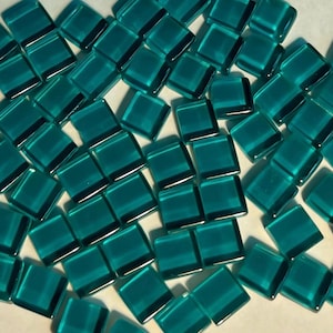 Könnte beinhalten: Eine große Menge an quadratischen Glasfliesen in Tealblau. Die Fliesen sind glatt und glänzend.