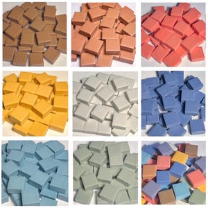 May include: A collection of square mosaic tiles in various colors, including brown, peach, red, yellow, white, blue, and green. The tiles are arranged in a grid, showcasing the range of hues available for crafting and decorative projects.