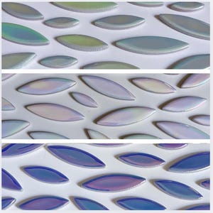 Può includere: Tre file di piastrelle in ceramica iridescente a forma di ovale. La fila superiore è di colore verde chiaro, la fila centrale è di colore viola chiaro e la fila inferiore è di colore blu chiaro.