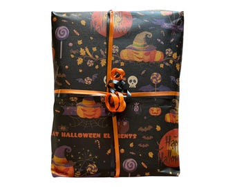 May include: A rectangular package wrapped in black paper featuring a colorful Halloween pattern of pumpkins, witch hats, skulls, bats, and candy. The package is tied with orange and black ribbons that form a decorative bow in the center.