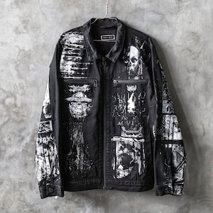 May include: Black denim jacket with a white graphic print of skulls, faces, and abstract designs. The jacket has a zipper closure and two pockets.