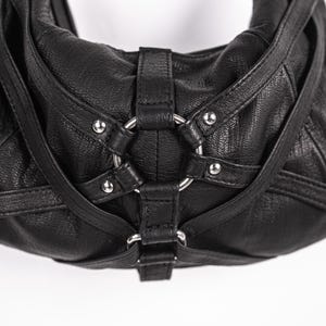 K&ouml;nnte beinhalten: Schwarze Hobo-Tasche aus Leder mit silberfarbenen Beschl&auml;gen. Die Tasche hat eine strukturierte Oberfl&auml;che, ein gro&szlig;es Metallringdetail und verstellbare Riemen. Ein stilvolles Accessoire f&uuml;r den Alltag.