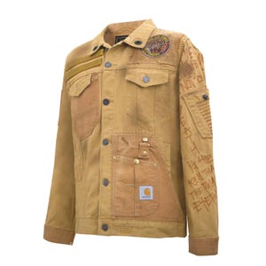 Puede incluir: Chaqueta vaquera Carhartt color canela con m&uacute;ltiples bolsillos, parches y texto en la manga derecha. La chaqueta presenta un parche redondo con un tigre y las palabras "Flying Air Force".