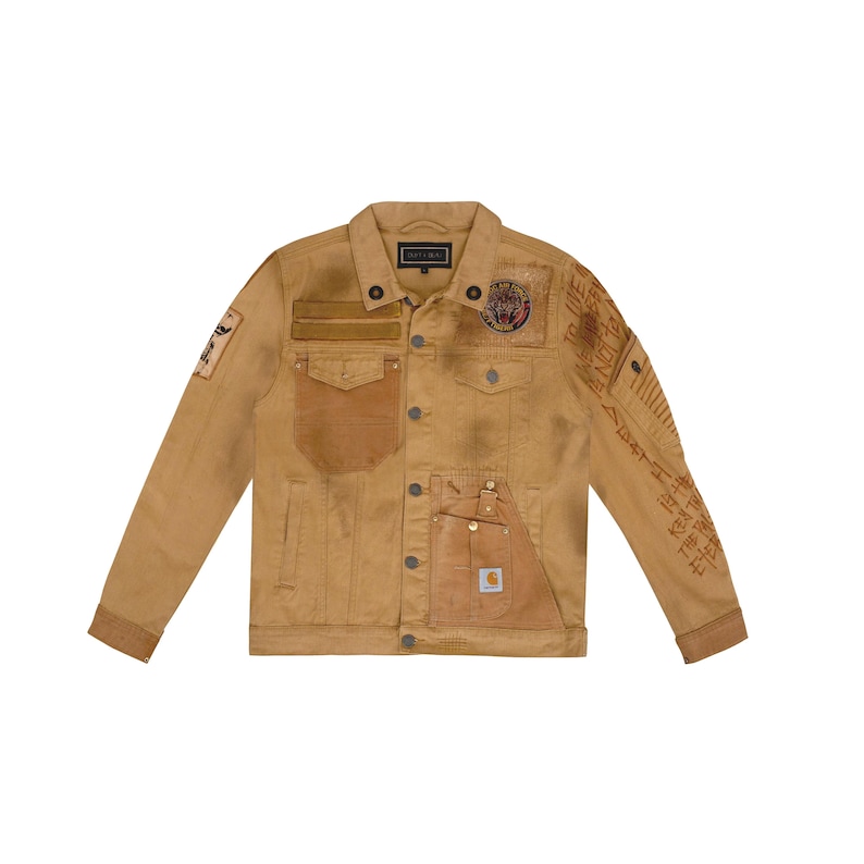 Puede incluir: Chaqueta vaquera color canela con m&uacute;ltiples parches y bolsillos. La chaqueta presenta un bolsillo Carhartt y parches decorativos en las mangas y el pecho. La chaqueta tiene cierre de botones y cuello cl&aacute;sico.