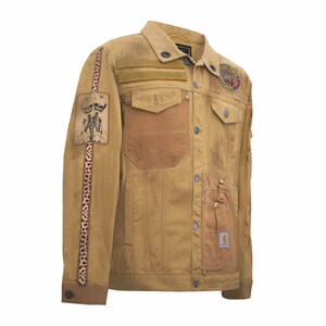 Puede incluir: Chaqueta vaquera color canela con m&uacute;ltiples bolsillos, parches y una franja con estampado de leopardo en la manga izquierda. Presenta un gr&aacute;fico de esqueleto y una etiqueta Carhartt. Cierre de botones y cuello.