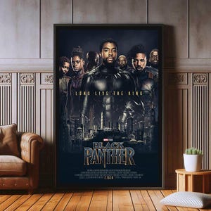 May include: Framed Black Panther film poster. It features a group of people in costume, with the text "LONG LIVE THE KING" at the top. The film title is in gold lettering at the bottom, with the release date.