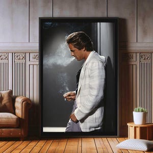Può includere: Un uomo con una giacca bianca a righe si trova in una porta, guardando in basso e tenendo una sigaretta nella mano destra. Indossa una camicia bianca e pantaloni scuri. Lo sfondo è una stanza buia con una porta.