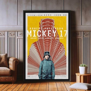 Op de afbeelding: Een filmposter voor de film "Mickey 17" geregisseerd door Bong Joon Ho. De poster toont Robert Pattinson in een blauw pak, staand in een gang met gespiegelde reflecties. De tekst op de poster luidt "Een film van Bong Joon Ho" en "Robert Pattinson Mickey 17".
