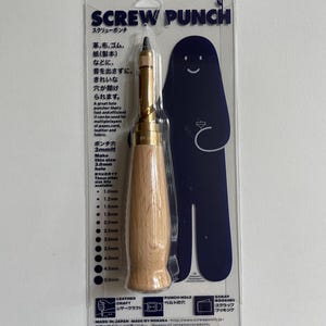 May include: A screw punch tool for leather craft, paper, and fabric. The tool has a wooden handle and a metal head with a screw mechanism. The packaging includes text in English and Japanese, with size options from 1.0mm to 5.0mm.