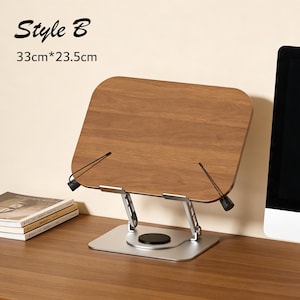 May include: A wooden book stand with a silver base and adjustable arms. The stand is 33cm x 23.5cm and features the text "Style B". The stand is designed to hold books or tablets.