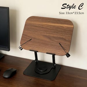 May include: A wooden book stand with a dark walnut finish, supported by a black metal frame. The stand is labeled "Style C" and measures 33cm x 23.5cm. The stand is designed to hold books or tablets.