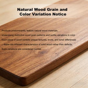 May include: Close-up of a rectangular wooden cutting board with rounded edges. The wood grain is visible, and the text "Natural Wood Grain and Color Variation Notice" is at the top. The text below describes the natural variations.