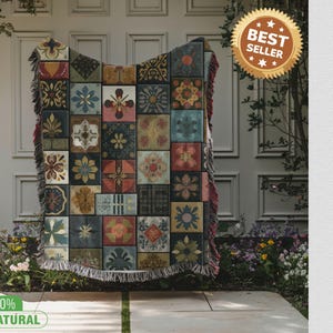 Peut inclure: Une couverture tissée avec un motif patchwork de motifs floraux et géométriques dans des tons de bleu, rouge, jaune et vert. La couverture a une bordure à franges et un autocollant "Best Seller".