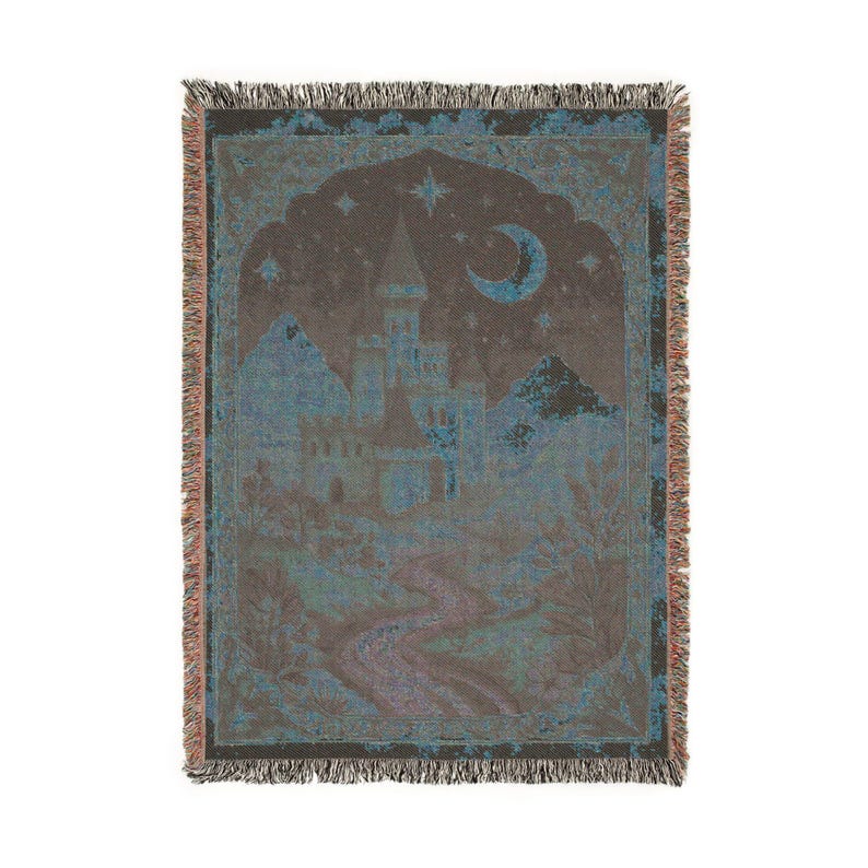 May include: A woven throw blanket featuring a dark brown and teal color palette. The design depicts a castle silhouette under a crescent moon and stars, with a winding path leading through a landscape of trees, finished with a fringed edge.