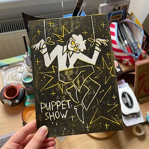 spectacle de marionnettes | 148х210 (A5) | linogravure imprimée sur du papier cartonné blanc et jaune | Chutes gravitationnelles de Stanford Pines