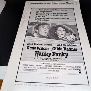 May include: A black and white movie poster for the film "Hanky Panky" starring Gene Wilder and Gilda Radner. The poster features a tagline: "Something Funny's Going On Here".