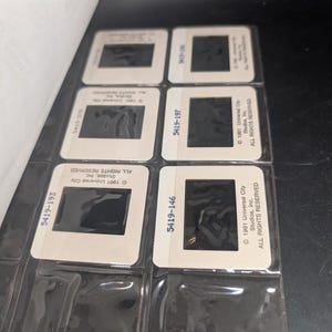 May include: A collection of film slides in protective sleeves. The slides are white-bordered with black film areas. Text on the slides includes "1991 Universal City Studios, Inc. ALL RIGHTS RESERVED" and slide numbers like "5419-193".