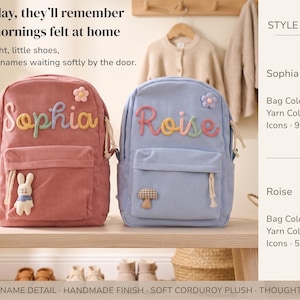 May include: Two corduroy backpacks, one rose and one blue, sit on a wooden bench. The rose backpack has the name "Sophia" in colorful yarn, a flower, and a bunny. The blue backpack has the name "Roise" and a mushroom.