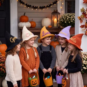 May include: Five children wearing pointed felt witch hats in black, cream, yellow, lavender, and orange. Each hat features a name embroidered in a contrasting color. The children hold small fabric trick-or-treat buckets shaped like pumpkins.