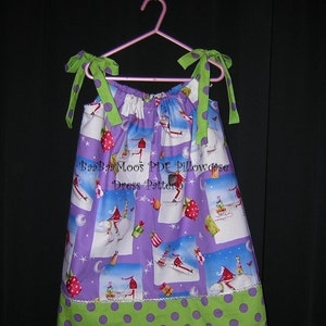 May include: A purple and green dress with a white background and a Christmas theme. The dress has a green polka dot trim and a green bow on each strap. The dress has the text "Ba Ba Moos PDF Pillowcase Dress Pattern" on the front.