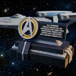 Peut inclure: Modèle 3D du vaisseau spatial U.S.S. Enterprise avec un emblème de Starfleet. Le modèle comprend une plaque avec les détails du vaisseau. L'arrière-plan présente une scène spatiale étoilée. Le modèle mesure environ 15 cm de long.