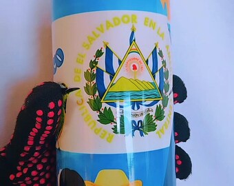 May include: A blue and white tumbler with a design featuring the flag of El Salvador, a cartoon couple in traditional clothing, and the text "Republica de El Salvador en la America Central".
