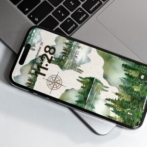 May include: A smartphone with a green and brown watercolor background featuring a compass and the date and time: Monday, September 30, 11:28.