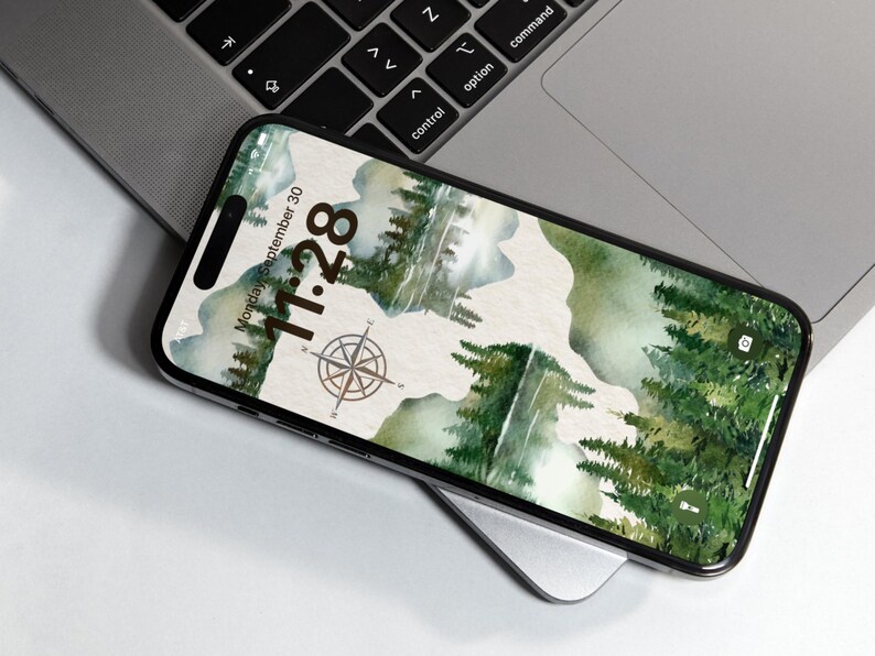 May include: A smartphone with a green and brown watercolor background featuring a compass and the date and time: Monday, September 30, 11:28.