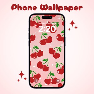Könnte beinhalten: Eine rosa Handy-Tapete mit einem Muster aus roten Kirschen. Der Bildschirm des Telefons zeigt die Uhrzeit 2:20 und das Datum Sonntag, den 3. November.