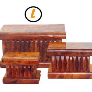 Peut inclure: Ensemble de trois boîtes à énigmes en bois de différentes tailles. Les boîtes sont d'un brun rougeâtre profond avec un grain de bois visible. Chaque boîte présente un motif sculpté distinctif sur les côtés, ce qui rehausse leur aspect décoratif. La lettre "L" est dans un cercle noir.