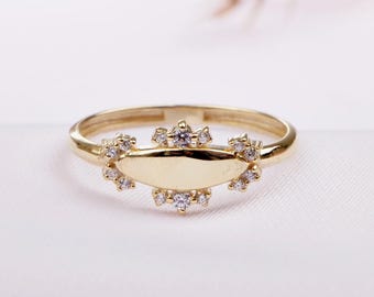 May include: A gold ring with a smooth oval band and a delicate halo of small diamonds.