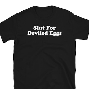 May include: Black t-shirt with the white text "Slut For Deviled Eggs" printed across the chest. The shirt is a short-sleeved crew neck style.