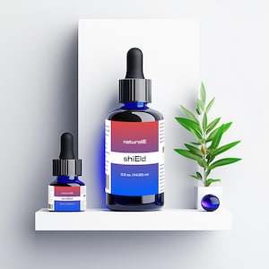 Può includere: Due bottiglie di vetro blu con contagocce, etichettate "naturalIE shiEld 0,5 oz (14,20 ml)". La bottiglia più piccola è davanti a quella più grande. Entrambe le bottiglie sono su uno scaffale bianco con una piccola pianta verde in un vaso bianco a destra.