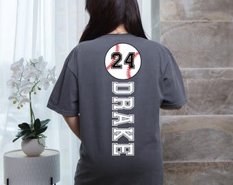 May include: A dark gray t-shirt with a white baseball graphic and the number 24. The name "DRAKE" is printed vertically down the back of the shirt.