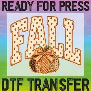 May include: A DTF transfer design featuring the word FALL in large, cream-colored block letters with brown polka dots. Below the text is a pumpkin with a plaid bow, featuring sections of leopard print, orange gingham, and floral patterns.