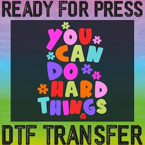 May include: A colorful graphic design with the text "You Can Do Hard Things" in a rainbow of colors with flowers surrounding the text. The design is on a black background with the text "READY FOR PRESS" at the top and "DTF TRANSFER" at the bottom.
