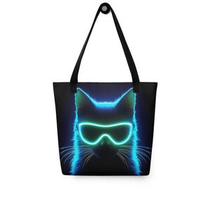 May include: A black tote bag with a neon blue cat wearing neon blue goggles. The cat's face is the main focus of the design.