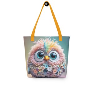 May include: A whimsical tote bag featuring a colorful, cartoon-like bird with large blue eyes and a button-covered body. The bird has a fluffy, textured appearance with rainbow-colored feathers. The bag has yellow straps and a light blue background.