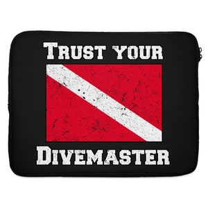 May include: Black laptop sleeve with white distressed text that reads "Trust Your Divemaster" and a red and white scuba diving flag.
