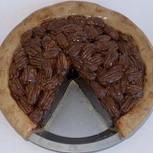 Fake Pie,Pecan Pie with slice missing in a light golden crust, 10x3”