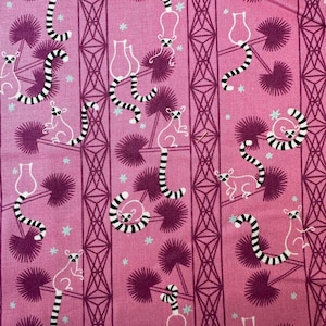 Peut inclure: Tissu rose avec un motif répété de lémuriens blancs avec des queues rayées noires et blanches, des palmiers violets foncés et des formes géométriques. De petites étoiles bleu clair sont dispersées dans le motif.