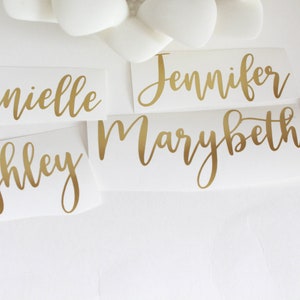 May include: Five gold vinyl stickers with the names Danielle, Ashley, Jennifer, Marybeth, and Lexi written in a cursive font.