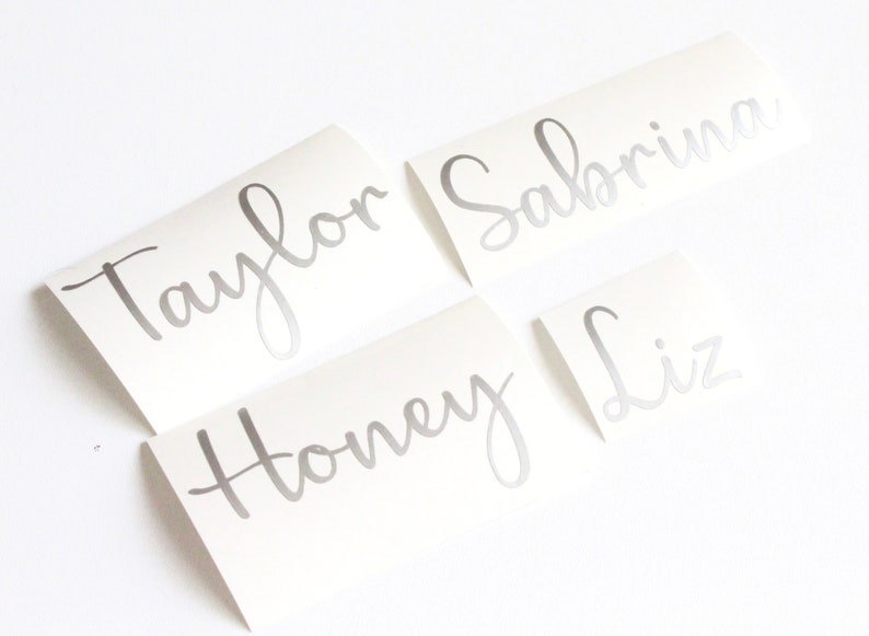 May include: Four silver vinyl stickers with names written in cursive: Taylor, Sabrina, Honey, and Liz.