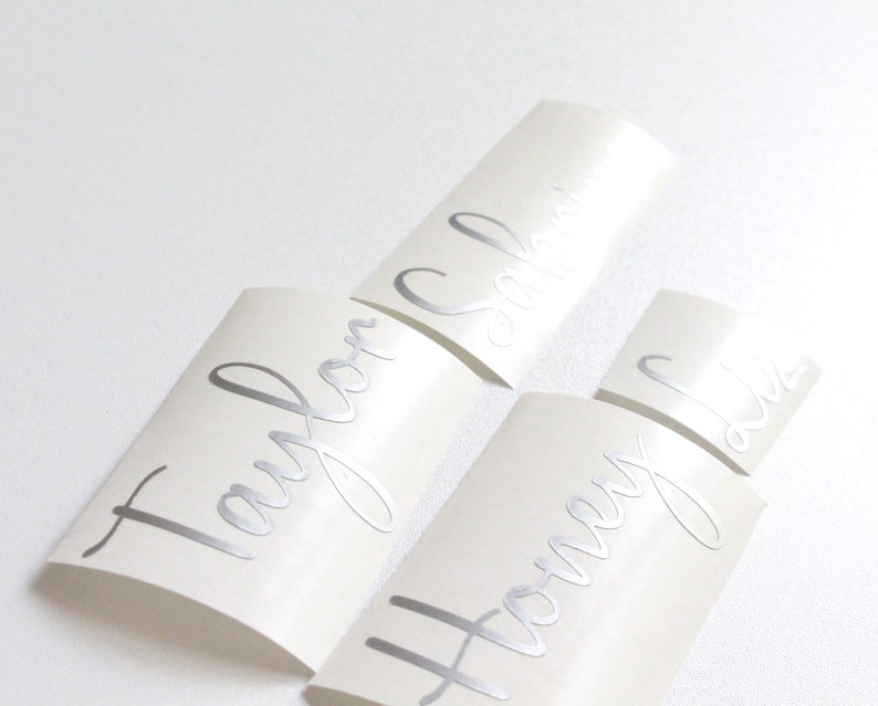 May include: Three white labels with silver lettering. The labels read "Taylor", "Honey", and "Sophia".