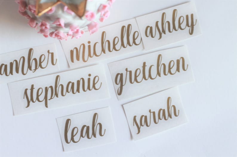 May include: Six gold foil name tags with the names Amber, Michelle Ashley, Stephanie, Gretchen, Leah, and Sarah.