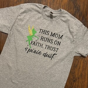May include: Gray t-shirt with a green Tinkerbell graphic and the text "This Mom Runs On Faith, Trust & Pixie Dust".