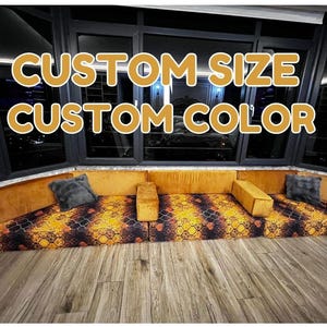 May include: A floor seating arrangement featuring mustard yellow velvet back cushions and a patterned seat base with orange, black, and gold geometric motifs. The text CUSTOM SIZE CUSTOM COLOR is overlaid in bold yellow letters against the dark window background.
