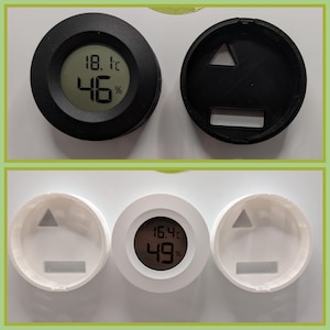 May include: Two digital hygrometers, one black and one white, displaying temperature in Celsius and humidity. Two black and two white circular covers with a triangular and rectangular cutout are also shown.