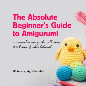 Peut inclure: Un guide de crochet amigurumi avec plus de 2,5 heures de tutoriels vidéo. La couverture présente un lapin rose, un poussin jaune et des boules de crochet colorées. Le texte indique "The Absolute Beginner's Guide to Amigurumi".